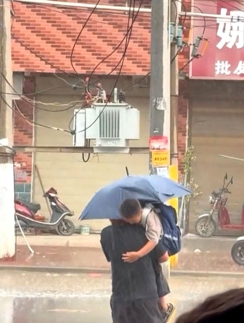 ภาพพ่อกางร่มไปรับลูกกลางสายฝน กลายเป็นไวรัลทำคนหลุดขำ
