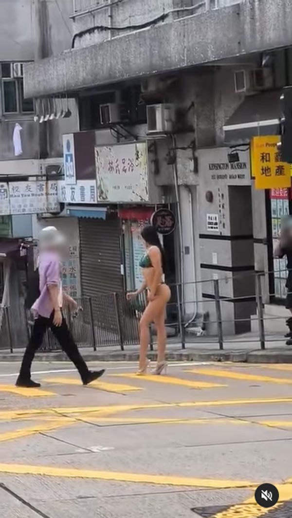 สาวสวมบิกินี่ยืนถ่ายภาพกลางถนน