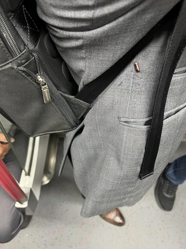 ชายแต่งตัวใส่สูทอย่างดี แต่มีเม็ดสีแดงแปลก ๆ ติด ชายแต่งตัวใส่สูทอย่างดี แต่มีเม็ดสีแดงแปลก ๆ ติด